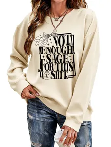 Detailed view of beige long sleeve sweatshirt featuring graphic text print and stylish ripped jeans.