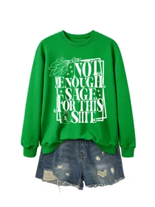 Green long sleeve sweatshirt detail with graphic print and denim shorts outfit match view.