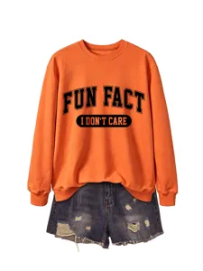 Sweat-shirt orange à motif fun fact associé à un short en jean déchiré, pull décontracté.