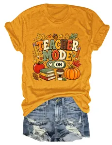 Detailopname van het gele leraar grafische t-shirt met schattige herfstelementen en denim.