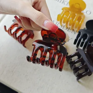 Detail shot of multi-color acetate hair claw clips, showing sturdy spring and stylish design.