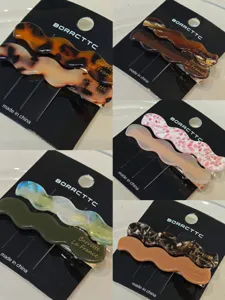 Detailed view of vintage acetate wavy hair clips, showcasing exquisite texture and fine finish.