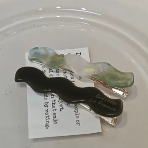 Retro acetate wave hair clips detail shot, elegant black and green marbled side hairpins.