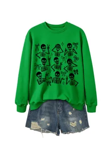 Close-up detail of green crewneck sweatshirt with cute skeleton graphic prints and bows.