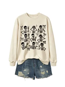 Detailed view of cream sweatshirt featuring playful black skeleton and bow graphics.
