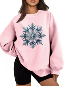 Close-up detail van dames roze sweatshirt met sprankelende blauwe sneeuwvlok patroon.