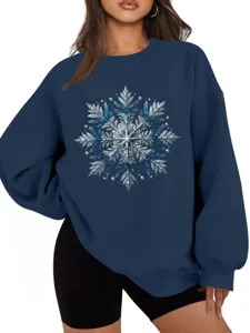 Detailopname van het sprankelende blauwe sneeuwvlokmotief op de gezellige trui.