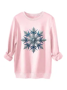 Detail van het sprankelende blauwe pailletten sneeuwvlokmotief op de gezellige roze trui.