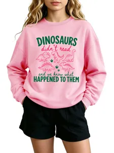 Detailed view of the pink dinosaur graphic sweatshirt featuring funny typography and cute prints.