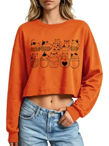 Close-up of the cute cat print on the orange cropped sweatshirt, showing playful cat details.