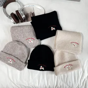 Detailed view of children's knitted beanie hat and cozy winter scarf set with cute puppy embroidery.