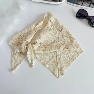 Close-up detail of the vintage beige crochet lace triangle scarf, soft knit texture and design.