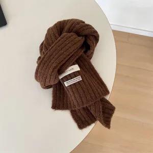 Kids brown knit scarf detail, winter warm neck warmer with chic fabric label texture.