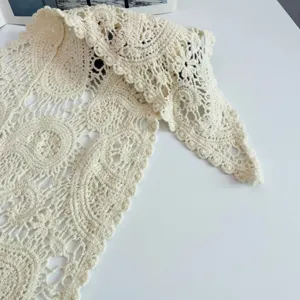 Crochet lace triangle scarf detail, off-white cotton floral knit shawl, elegant summer wrap.