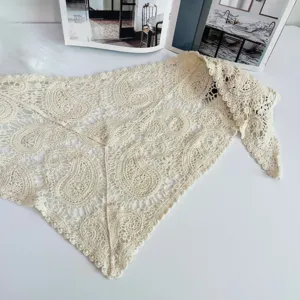 Close-up detail of the beige crochet hollow lace triangle scarf, showing delicate knit pattern.