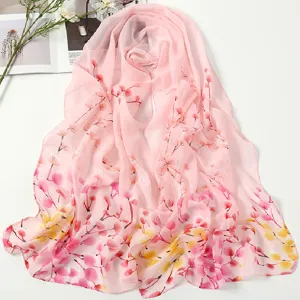 Detailed view of the pink chiffon floral scarf, elegant branch print texture and soft fabric.