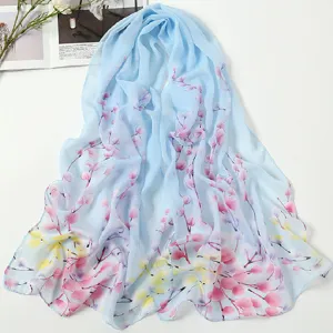 Light blue chiffon scarf featuring a delicate pink floral print, elegant and breathable.