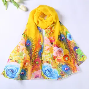Detail view of the vibrant yellow floral and peacock feather print chiffon scarf, elegant accessory.