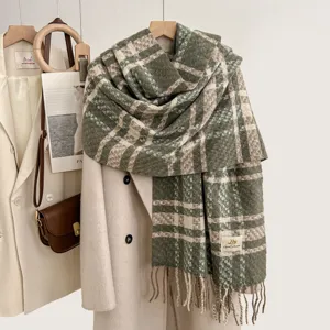 Close-up detail of the cozy green plaid cashmere-feel winter scarf featuring soft tassel edges.