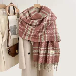 Detailed view of cozy pink plaid imitation cashmere scarf with fringe, soft winter shawl.