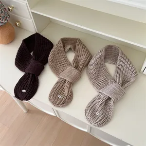 Cozy knitted kids cross scarves detail showing soft texture and three neutral color options.