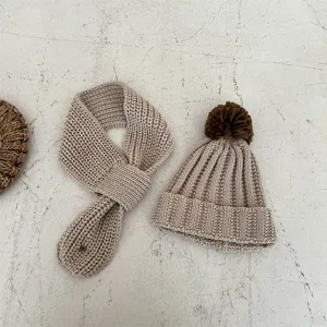 Kids winter warm knit hat and scarf set, cozy beige wool beanie with brown pom-pom detail.