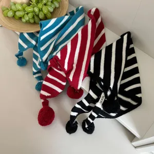 Children knitted striped scarf detail view, featuring cute pom-pom and pointy design.