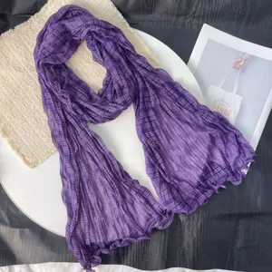 Detail view of the purple crinkled gauze scarf, showing lightweight texture and fine pleats.