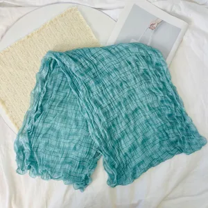 Close up of teal pleated gauze scarf texture, delicate fabric details for summer fashion.