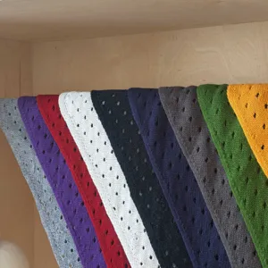 Vista detallada de pañuelos triangulares de punto multicolor ordenados, textura suave.