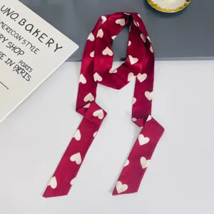 Detailed close-up view of the red heart-printed long skinny silk scarf neck ribbon accessory.