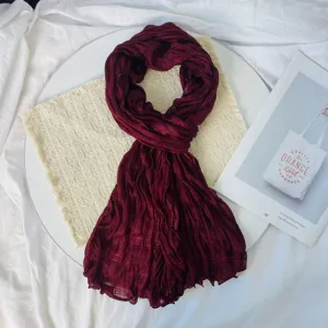 Detail shot of a burgundy pleated scarf, lightweight breathable long wrap for women daily wear.