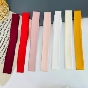 Detailed shot of colorful skinny satin silk scarves, ideal for hair, bags, and neck.