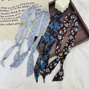 Close up of vintage floral twilly scarves with pearl rings, flat lay details view.