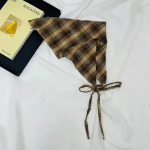 Brown plaid children triangle headscarf detail, vintage grunge style distressed fabric.
