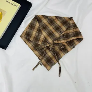 Detailed view of brown plaid kids triangle scarf, retro distressed fringe and tie design.