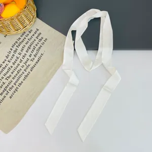 Solid white narrow satin silk scarf detail showing smooth texture and ribbon design.
