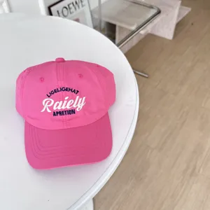 Gedetailleerde close-up van een roze geborduurde honkbalpet, zachte bovenkant voor zomerse zon.