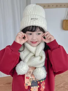 Cozy children knit winter beanie and pom-pom scarf set in white, soft and warm for kids.
