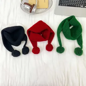 Close-up details of children knitted winter scarves with cute pom-poms in multiple colors.