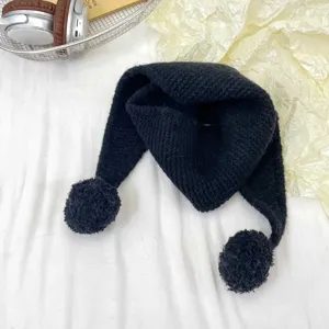 Kids black knitted hat scarf with cute pom poms, soft warm winter neck warmer accessory detail.