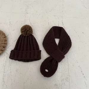 Kids brown knit beanie hat and scarf set, cozy winter warm pompom knitwear detail.