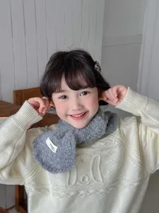 Detail view of kids winter fuzzy cross scarf close-up soft warm neck warmer for boys and girls