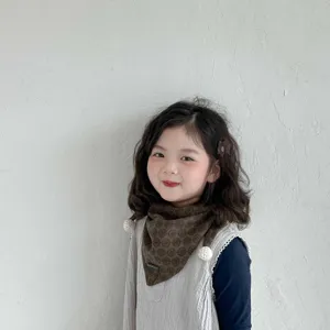 Detailed view of kids autumn winter warm triangular scarf with cute pom pom design and soft fabric.