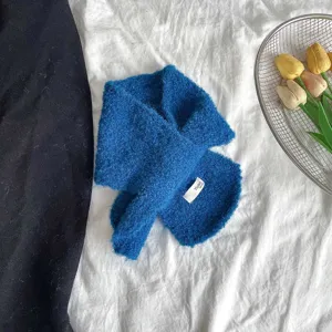 Detailed view of the blue fuzzy cross scarf featuring a soft textured knit and small brand label.