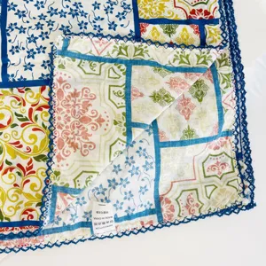 Detailed view of a cotton square scarf with vintage patchwork floral print and blue lace border.