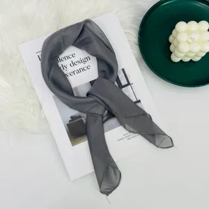 Piccolo fazzoletto quadrato in seta sottile grigio scuro da donna, elegante dettaglio di foulard.