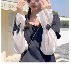 Gros plan de manches de protection UV blanches transparentes avec des nœuds noirs.