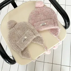 Détail de bonnet en tricot chaud pour enfants, joli pompon, cache-oreilles, confortable.