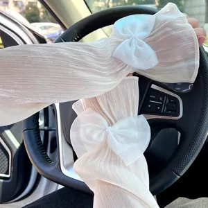 Manchettes de protection solaire plissees blanches avec noeuds pour la conduite auto.